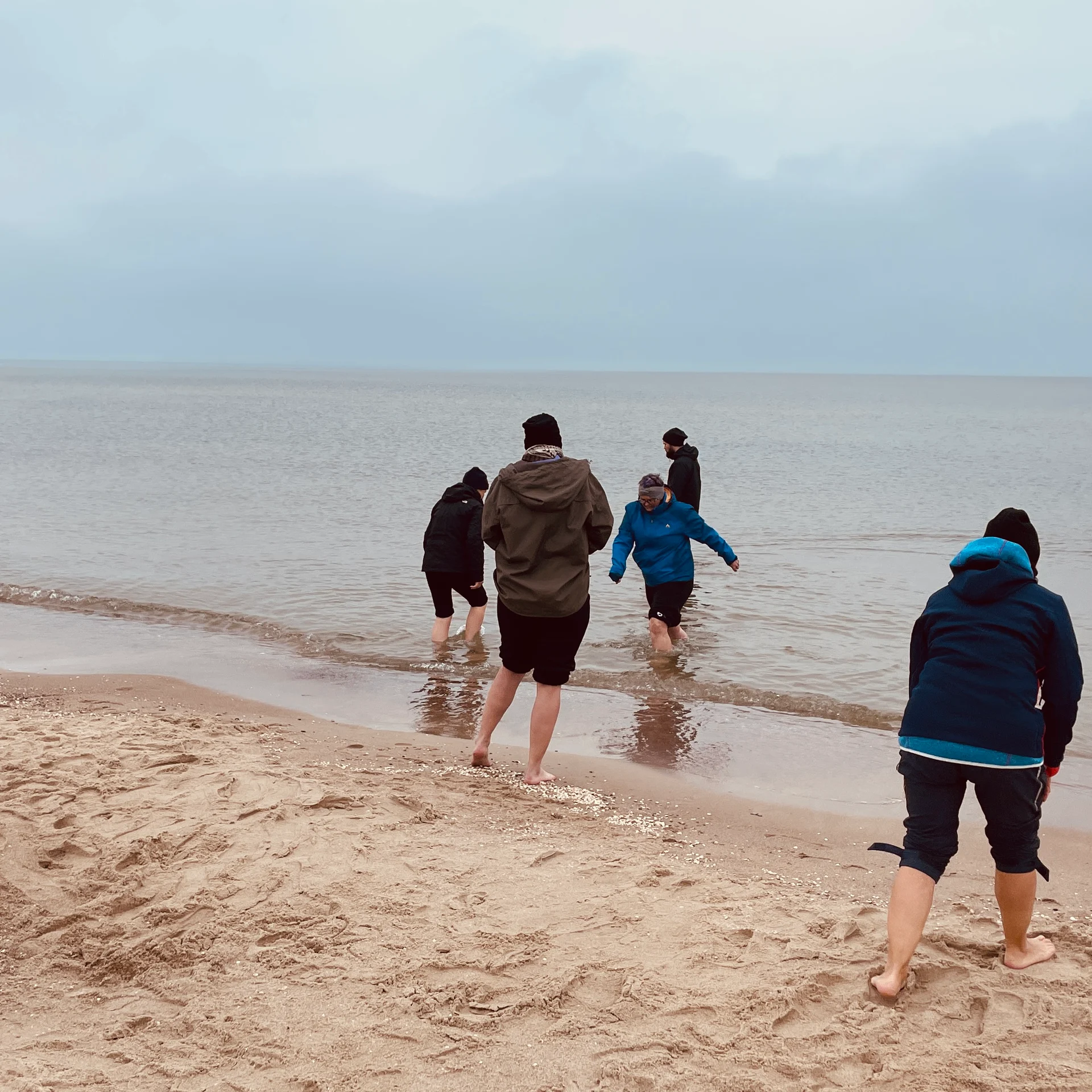 Reiseteilnehmer beim Gehen durch das flache Meerwasser